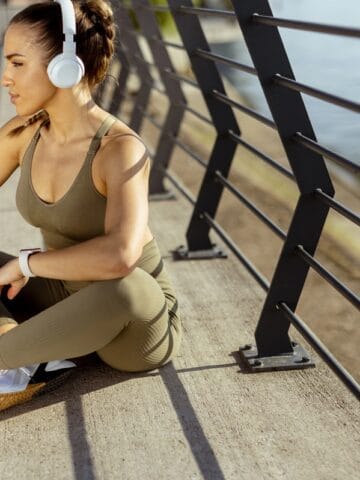 A woman sitting outside after her run.